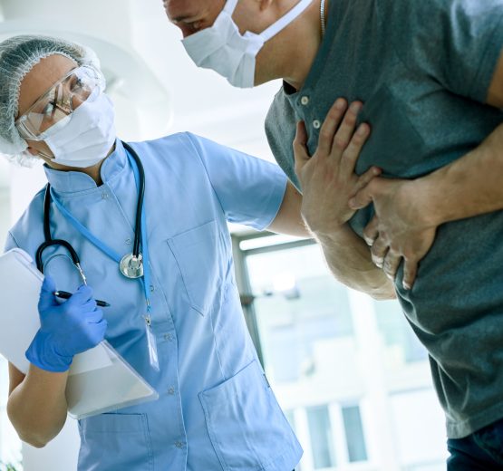 Female doctor with a patient who is complaining of chest pain during coronavirus epidemic.